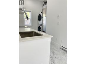 Vancouver apartment for rent - A white kitchen with a sink and a window.