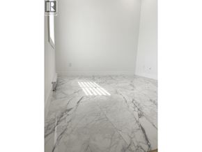 Vancouver apartment for rent - A white room with a marble floor and a realtor sign on the wall.