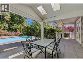 West Vancouver apartment for rent - A patio with a table and chairs overlooking a pool.