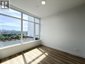 Burnaby apartment for rent - A sunny room with a view of the cityscape outside the window.