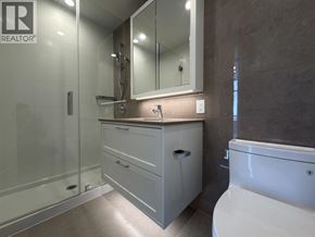 Burnaby apartment for rent - A bathroom with a white tub and a large mirror above the sink.