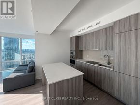 Toronto (Bay Street Corridor) condo for rent - A modern kitchen with wooden cabinets and a large island.