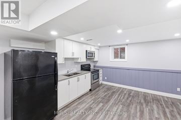Ajax (Central East) apartment for rent - A kitchen with a black refrigerator and wooden floors.