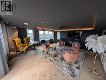 Oakville (Go Glenorchy) condo for rent - A living room with a yellow chair and a fluffy white decoration.