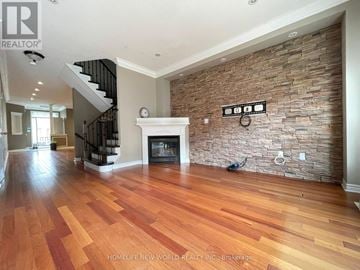 Markham (Berczy) apartment for rent - A living room with a stone wall and wood flooring.
