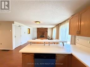 Barrie (Northwest) apartment for rent - A kitchen with wooden cabinets and a white countertop.