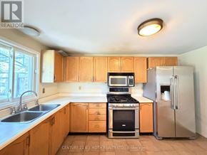 Barrie (Northwest) apartment for rent - A kitchen with wooden cabinets and stainless steel appliances.
