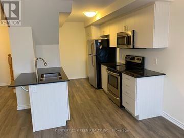 Kitchener townhouse for rent - A kitchen with white cabinets and black countertops.