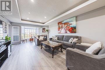 Hamilton (Meadowlands) condo for rent - A living room with a grey couch, a coffee table, and a painting on the wall.