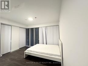 Toronto (Kensington-Chinatown) condo for rent - A bedroom with a bed, a window with curtains, and a ceiling light.