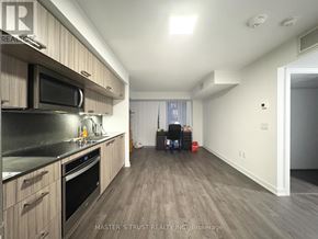 Toronto (Kensington-Chinatown) condo for rent - A kitchen with a black countertop and stainless steel appliances.
