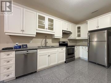 King (King City) apartment for rent - A kitchen with white cabinets and stainless steel appliances.