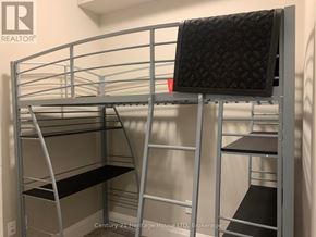 Guelph (St. Patrick's Ward) condo for rent - A metal bunk bed with a black mattress on top and a grey mattress on the bottom.