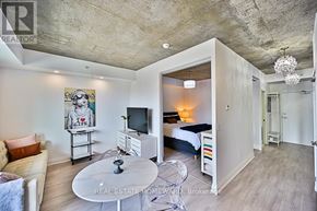 Toronto (Waterfront Communities) condo for rent - A bedroom with a bed, nightstand, and a painting of a cowboy on the wall.