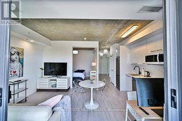 Toronto (Waterfront Communities) condo for rent - A modern living room with a white couch and a television.