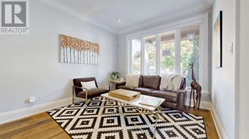 Toronto (Lansing-Westgate) apartment for rent - A living room with a brown couch, a coffee table, and a rug with a black and white pattern.
