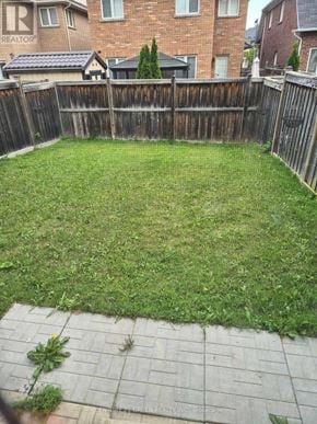 Milton (Be Beaty) apartment for rent - A backyard with a wooden fence and a green lawn.