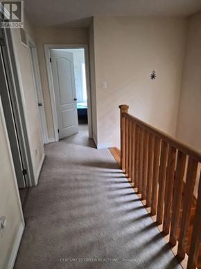 Milton (Be Beaty) apartment for rent - A hallway with a carpeted floor and a wooden railing.