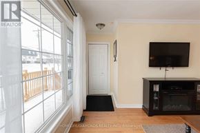 Halton Hills (Georgetown) apartment for rent - A living room with a flat screen TV mounted on the wall and a white door in the background.