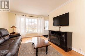 Halton Hills (Georgetown) apartment for rent - A living room with a black leather couch, a wooden coffee table, and a flat screen TV mounted on the wall.