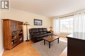 Halton Hills (Georgetown) apartment for rent - A living room with a black leather couch and a wooden bookcase.