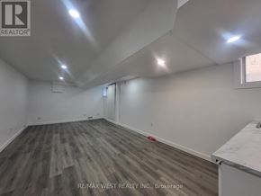 Toronto (Broadview North) triplex for rent - A room with wooden flooring and white walls, with a window on the right side.