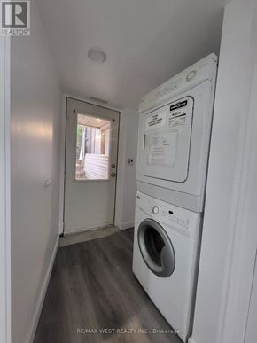 Toronto (Broadview North) triplex for rent - A white dryer is in a small room with a doorway leading to a hallway.