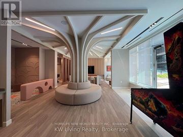 Toronto (Regent Park) condo for rent - A modern living room with a central column and a large painting on the wall.