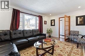 Brantford apartment for rent - A living room with a black leather couch and a coffee table.