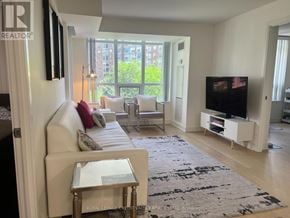 Mississauga (City Centre) condo for rent - A modern kitchen with a large island and a view of the backyard.
