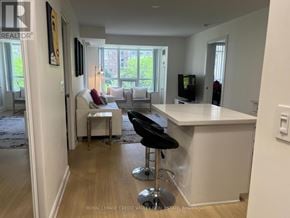 Mississauga (City Centre) condo for rent - A white kitchen with black appliances and a white island.