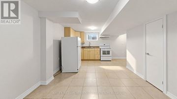 Toronto (Newtonbrook West) apartment for rent - A white refrigerator is in a kitchen with white walls and a white floor.
