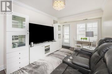 Brampton (Northwest Brampton) condo for rent - A living room with a black leather couch and a flat screen TV.