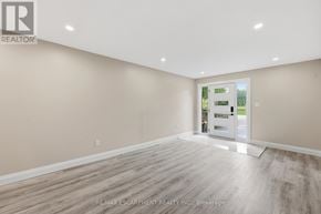 Hamilton duplex for rent - A room with beige walls and wooden flooring, with a doorway leading to a balcony.