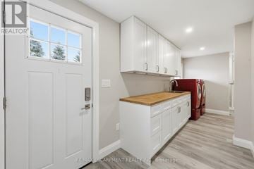 Hamilton duplex for rent - A white kitchen with a wooden counter top and cabinets.