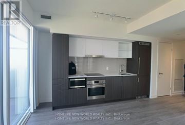 Toronto (Waterfront Communities) condo for rent - A modern kitchen with dark wood cabinets and stainless steel appliances.