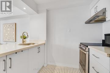 Toronto (Kensington-Chinatown) condo for rent - A kitchen with white cabinets and a black stove top oven.