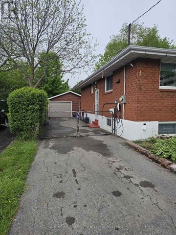 Oshawa (Mclaughlin) apartment for rent - A residential street with a red brick house and a tree.