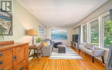 Oshawa (Mclaughlin) apartment for rent - A living room with a couch, chair, and a painting on the wall.