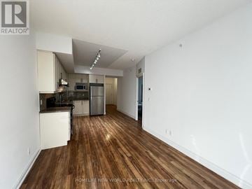 Markham (Unionville) condo for rent - A kitchen with white cabinets and a wooden floor.