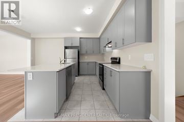 Kawartha Lakes (Lindsay) townhouse for rent - A kitchen with grey cabinets and a white fridge.