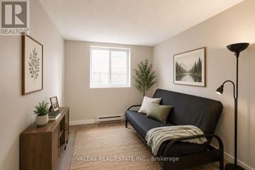 London East (East H) condo for rent - A living room with a black couch and a lamp.