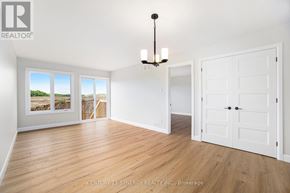 North Stormont duplex for rent - A Synergy Realty Inc. brokerage logo is displayed on a wall in a spacious room with hardwood floors and white walls.