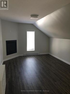 Kitchener duplex for rent - A room with a window and wooden flooring.