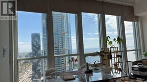 Toronto (Waterfront Communities) condo for rent - A room with a large window overlooking a cityscape.