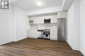 Toronto (West Hill) condo for rent - A kitchen area with a refrigerator, microwave, and oven.
