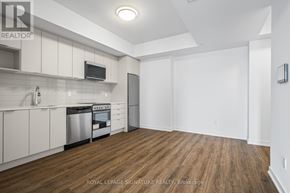 Toronto (West Hill) condo for rent - A kitchen with white cabinets and a wooden floor.
