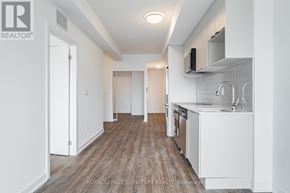 Toronto (West Hill) condo for rent - A kitchen with white cabinets and a wooden floor.