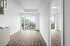Toronto (West Hill) condo for rent - A spacious room with wooden flooring and white walls, with a sliding glass door leading to a balcony.