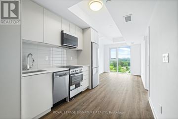 Toronto (West Hill) condo for rent - A modern kitchen with white cabinets and stainless steel appliances.